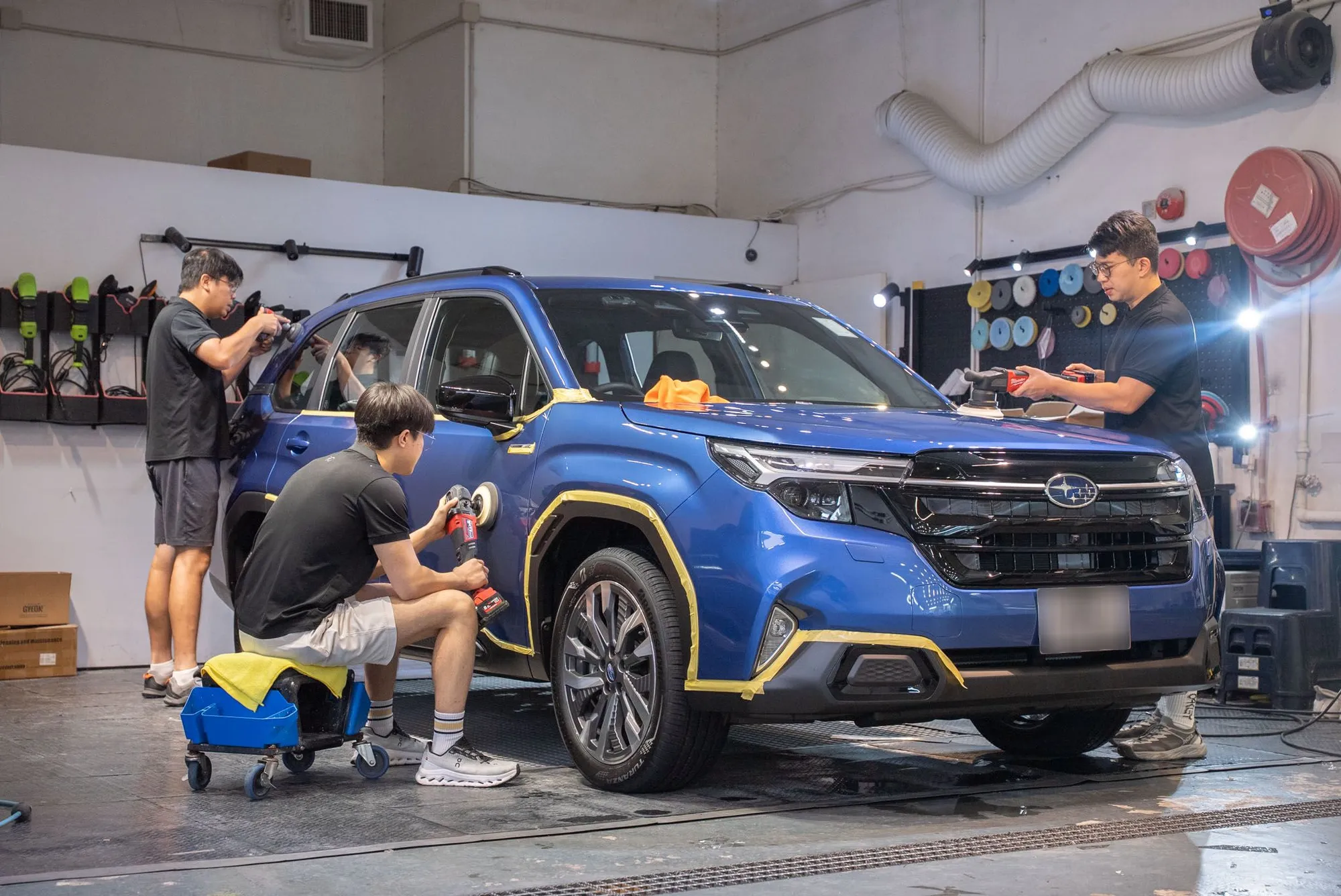團隊同時以不同大小拋光機處理 Subaru Forester 車身