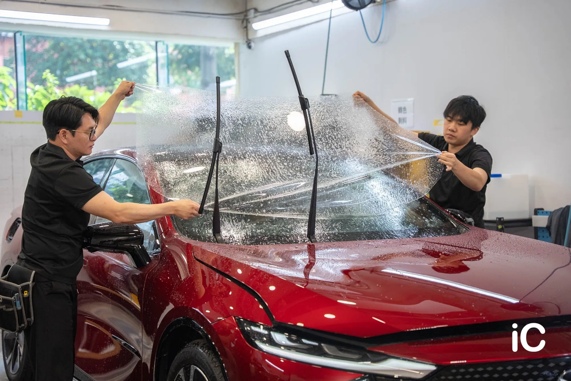 同事將擋風玻璃保護膜鋪在 Mazda 6e 前擋玻璃上