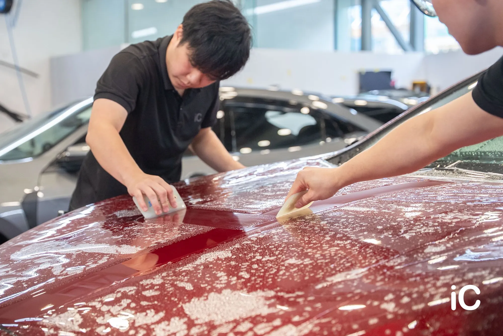 同事以刮板逐步貼合 Mazda 6e 頭冚上的 PPF