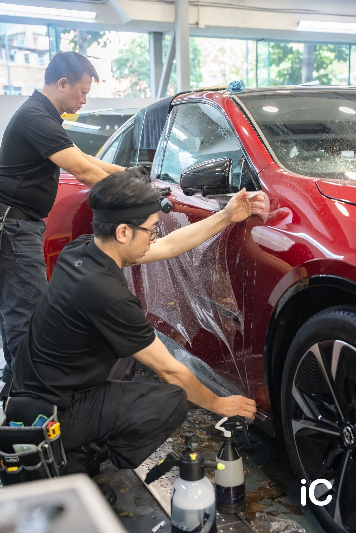 兩位同事配合貼合 Mazda 6e 車門位置的 PPF