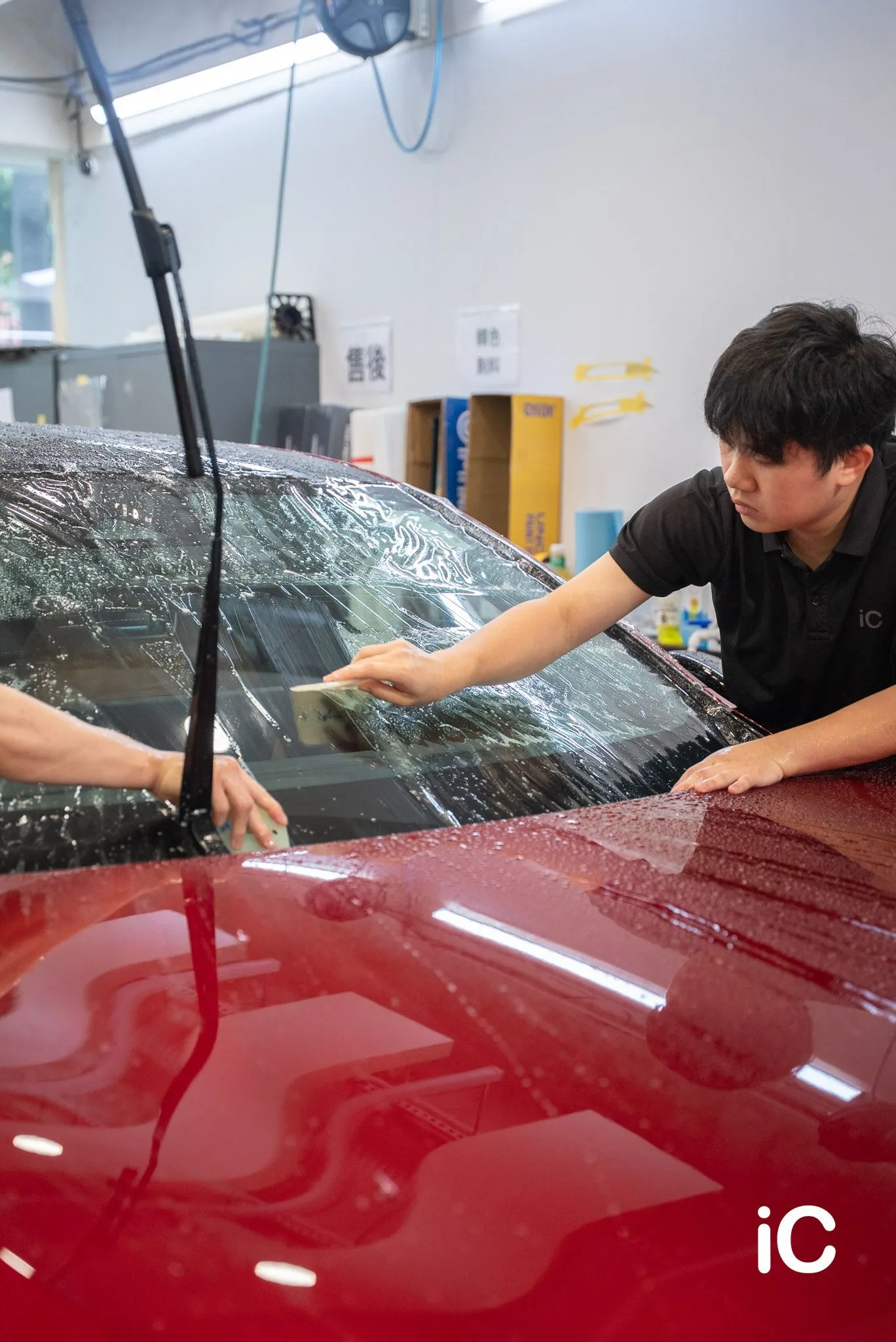 以刮板貼合 Mazda 6e 擋風玻璃上的保護膜